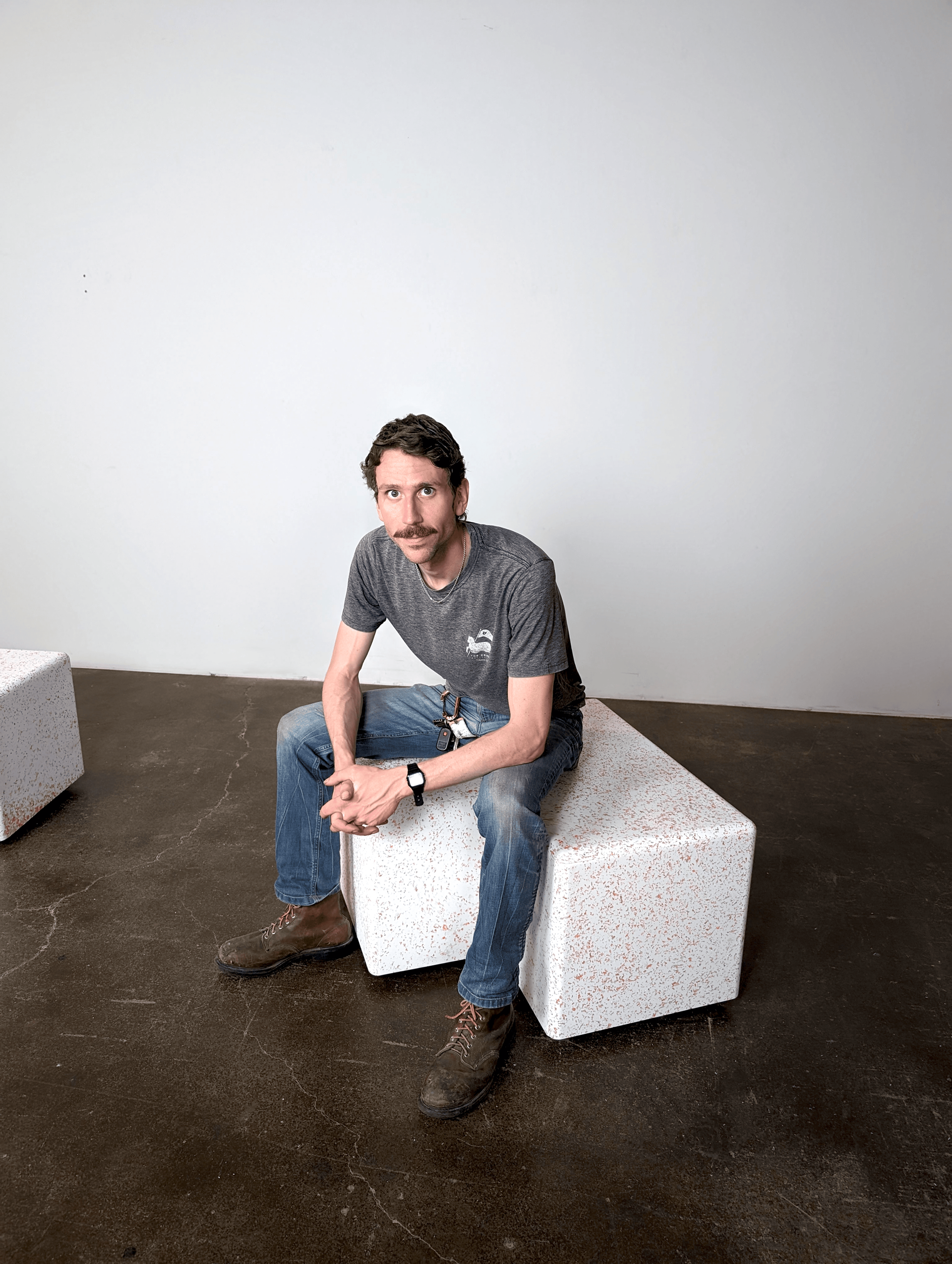 Joseph Klatt seated on a Marble Plastics bench made from recycled yogurt containers.